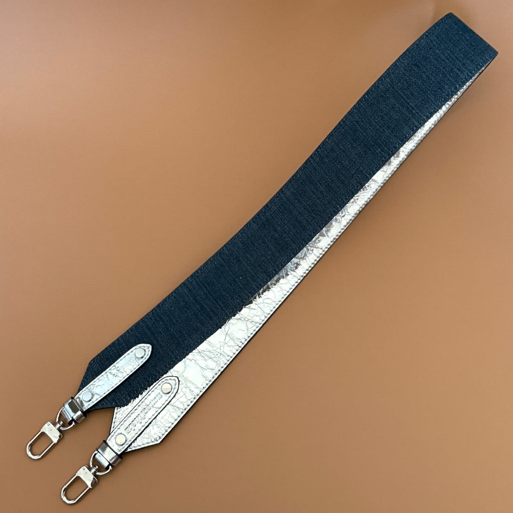 Reva reversible bag strap showing silver metallic leather side and denim side